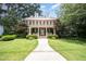 Attractive brick home with lush landscaping, a welcoming front porch, symmetrical design, and dormer windows at 1414 Park Dr, Raleigh, NC 27605