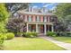 Stately two-story brick home with a covered front porch, lush landscaping, and a well-manicured lawn at 1414 Park Dr, Raleigh, NC 27605