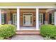 Inviting front porch with classic columns, rocking chairs, and neat landscaping at 1414 Park Dr, Raleigh, NC 27605