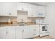 Bright kitchenette with white cabinets, modern appliances, and tile floor at 1414 Park Dr, Raleigh, NC 27605