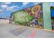 Colorful 'Village District' mural with vibrant flowers and local storefronts on a brick wall at 1414 Park Dr, Raleigh, NC 27605