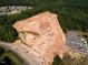 Aerial view of construction site with heavy machinery and cleared land for new homes near a wooded area at 147 Rivulet Ct, Cary, NC 27519