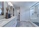 Bright bathroom featuring a double vanity, tiled floor and a frameless glass shower with bench at 147 Rivulet Ct, Cary, NC 27519