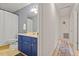 Bathroom featuring a blue vanity, updated fixtures, and patterned wallpaper at 1523 Oak Forest Dr, Hillsborough, NC 27278