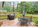 Wooden deck features outdoor furniture, including a dining table with a metal frame and black chairs at 1523 Oak Forest Dr, Hillsborough, NC 27278