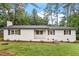 Charming single-story home with a white painted brick exterior, black shutters and a well-manicured lawn at 1523 Oak Forest Dr, Hillsborough, NC 27278