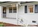 Inviting front porch with white railing, brick steps, and a charming front door at 1523 Oak Forest Dr, Hillsborough, NC 27278