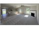 Open-concept living room featuring high ceilings, a cozy fireplace, and access to the adjacent kitchen at 154 Oakfield Trace Dr, Four Oaks, NC 27524