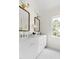 Bright bathroom featuring double vanity with marble countertop, brass fixtures, and hexagonal tile flooring at 16 Cedar Hill Dr, Durham, NC 27713