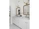 Bright bathroom featuring double vanity with marble countertop, brass fixtures, and hexagonal tile flooring at 16 Cedar Hill Dr, Durham, NC 27713