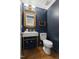 Charming powder room featuring a modern sink with golden fixtures and a wood-framed mirror at 16 Cedar Hill Dr, Durham, NC 27713