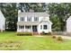 Charming two-story home with blue shutters, inviting front porch, manicured lawn, and mature trees at 16 Cedar Hill Dr, Durham, NC 27713