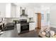 Bright kitchen featuring white cabinets, stainless steel appliances, black countertops and hardwood flooring at 16 Cedar Hill Dr, Durham, NC 27713