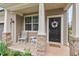Inviting front porch with rocking chairs, stone accents and a decorative wreath on the front door at 1924 Rustica Dr, Durham, NC 27713