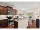 Modern kitchen featuring stainless steel appliances, granite countertops, and stylish dark wood cabinetry at 1924 Rustica Dr, Durham, NC 27713