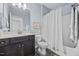 Bright bathroom featuring a modern vanity with dark wood cabinetry, shower-tub combo, and light blue walls at 20 Sweet Birch Row, Youngsville, NC 27596