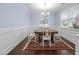 Stylish dining room features hardwood floors, wainscoting, and a classic chandelier, creating a refined ambiance at 20 Sweet Birch Row, Youngsville, NC 27596
