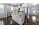 Modern kitchen features stainless steel appliances, granite countertops, and an island with seating at 20 Sweet Birch Row, Youngsville, NC 27596