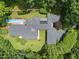 A captivating aerial view highlighting the home's roof, pool, and impeccably maintained green spaces at 213 Chimeneas Pl, Chapel Hill, NC 27517