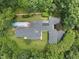 An aerial view of the property showing the shape of the home, its pool, and surrounding landscaping at 213 Chimeneas Pl, Chapel Hill, NC 27517