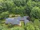 Stunning aerial view of a sprawling estate nestled amidst lush greenery, showcasing a private pool and meticulously landscaped grounds at 213 Chimeneas Pl, Chapel Hill, NC 27517