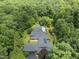 Breathtaking aerial view of a secluded home, featuring a long pool, surrounded by verdant forest for ultimate privacy at 213 Chimeneas Pl, Chapel Hill, NC 27517