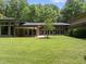 Lush backyard featuring a spacious lawn, perfect for outdoor activities, and views of the home's large windows at 213 Chimeneas Pl, Chapel Hill, NC 27517