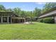 A large backyard featuring a patio, luscious trees, and lawn for outdoor living and enjoyment at 213 Chimeneas Pl, Chapel Hill, NC 27517