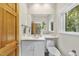 Powder room featuring wooden door, sleek vanity, toilet, and window to the outdoors, creating a well-lit space at 213 Chimeneas Pl, Chapel Hill, NC 27517