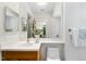 Bright bathroom featuring a wooden vanity, ceramic sink, a large frameless mirror, and a tiled wall at 213 Chimeneas Pl, Chapel Hill, NC 27517