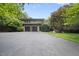 Beautiful home exterior featuring a well-manicured lawn, mature trees, and an attached garage at 213 Chimeneas Pl, Chapel Hill, NC 27517