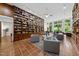 Bright library with floor-to-ceiling shelves, a ceiling fan, and comfortable seating area at 213 Chimeneas Pl, Chapel Hill, NC 27517
