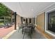 Covered outdoor dining area with seating for eight and exterior views of the manicured landscape at 213 Chimeneas Pl, Chapel Hill, NC 27517
