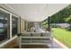Covered patio with comfortable seating overlooking a well-maintained lawn and landscaped backyard at 213 Chimeneas Pl, Chapel Hill, NC 27517