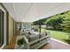 Covered patio with comfortable seating and view of manicured backyard at 213 Chimeneas Pl, Chapel Hill, NC 27517
