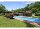 Stunning in-ground swimming pool with an inviting blue hue, surrounded by lush greenery and a well-manicured lawn at 213 Chimeneas Pl, Chapel Hill, NC 27517
