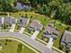 Aerial view of the houses and neighborhood, showcasing a pond nearby, with lush green landscaping at 2713 Jazzy St, New Hill, NC 27562
