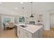 Bright, modern kitchen with quartz countertops and stainless steel appliances opening up to a dining and living space at 2713 Jazzy St, New Hill, NC 27562