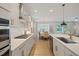 Modern kitchen with white cabinets, stainless steel appliances, and an open layout into the dining area at 2713 Jazzy St, New Hill, NC 27562