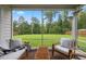 Relaxing screened-in porch showcases comfortable seating and stunning views of a lush green yard at 2713 Jazzy St, New Hill, NC 27562