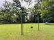 Expansive backyard showcasing lush green grass, mature trees, and swing set and trampoline at 275 Gholson Ave, Henderson, NC 27536