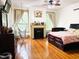 Spacious bedroom boasts hard wood floors, a fire place, natural light, and a modern ceiling fan at 275 Gholson Ave, Henderson, NC 27536