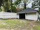 Detached garage with solar panel and partial view of the white fenced in backyard at 275 Gholson Ave, Henderson, NC 27536