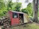 Red storage shed with a wood pile stored outside, useful for housing tools and equipment at 275 Gholson Ave, Henderson, NC 27536