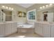Bright bathroom featuring double sinks, a garden tub and a large window at 300 Williamston Ridge Dr, Youngsville, NC 27596