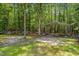 Image shows a metal carport surrounded by trees, offering covered parking or storage space on the property at 300 Williamston Ridge Dr, Youngsville, NC 27596
