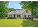 Charming white two-story home featuring a well-manicured lawn, mature trees, and inviting curb appeal at 300 Williamston Ridge Dr, Youngsville, NC 27596