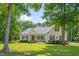 Charming white two-story home with manicured lawn and mature trees under a blue sky at 300 Williamston Ridge Dr, Youngsville, NC 27596