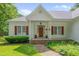 Close-up of the inviting front porch, red brick steps and wood-stained front door at 300 Williamston Ridge Dr, Youngsville, NC 27596