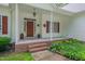 Covered front porch with classic details like red shutters and manicured landscaping at 300 Williamston Ridge Dr, Youngsville, NC 27596